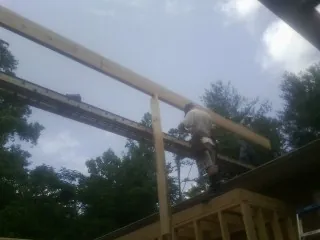 Carpenter setting a ridge beam over a new addition frame — Ice Dam Removal by Roofing Brothers in North Conway