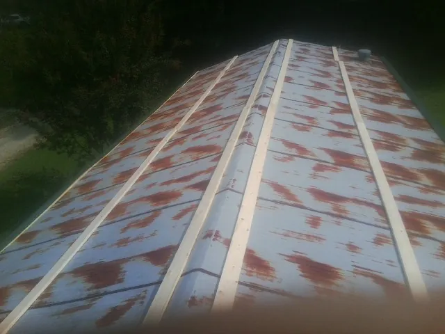 Rusted metal roof panels with new wood purlins before replacement — Storm Damage Roof Repair in North Conway by Roofing Brothers