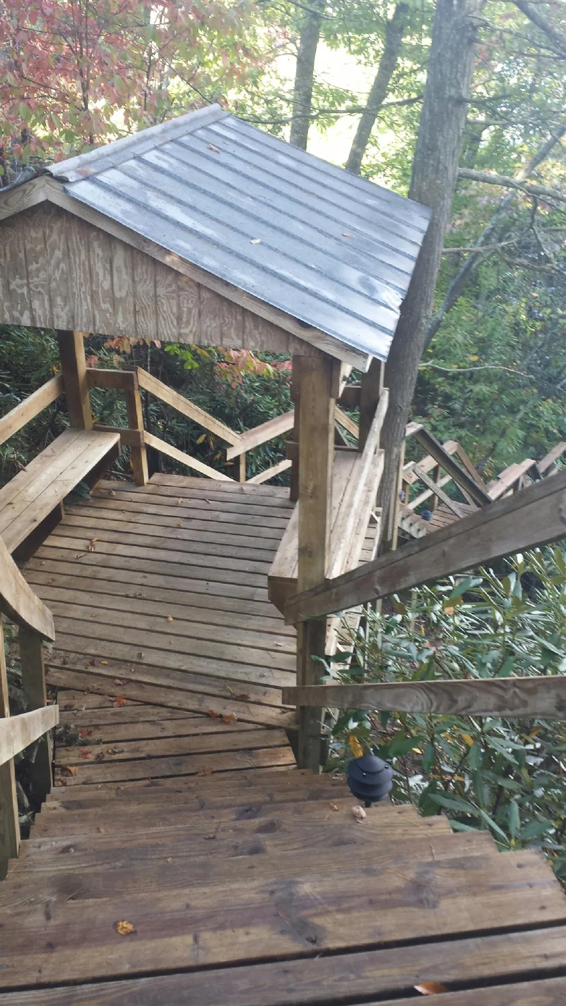 Metal roofed shelter over wooden steps on a wooded walkway — Skylight Repair & Installation work by our crew in North Conway