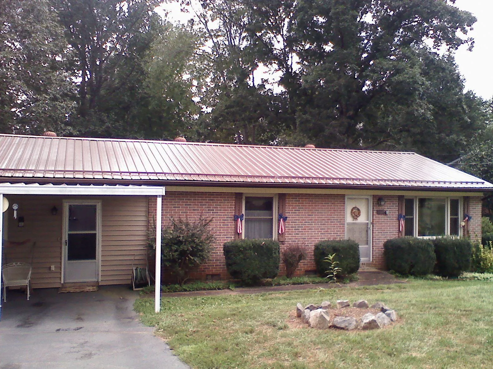 Bronze metal roof and carport on a brick ranch home — Roof Repair work by our crew in North Conway